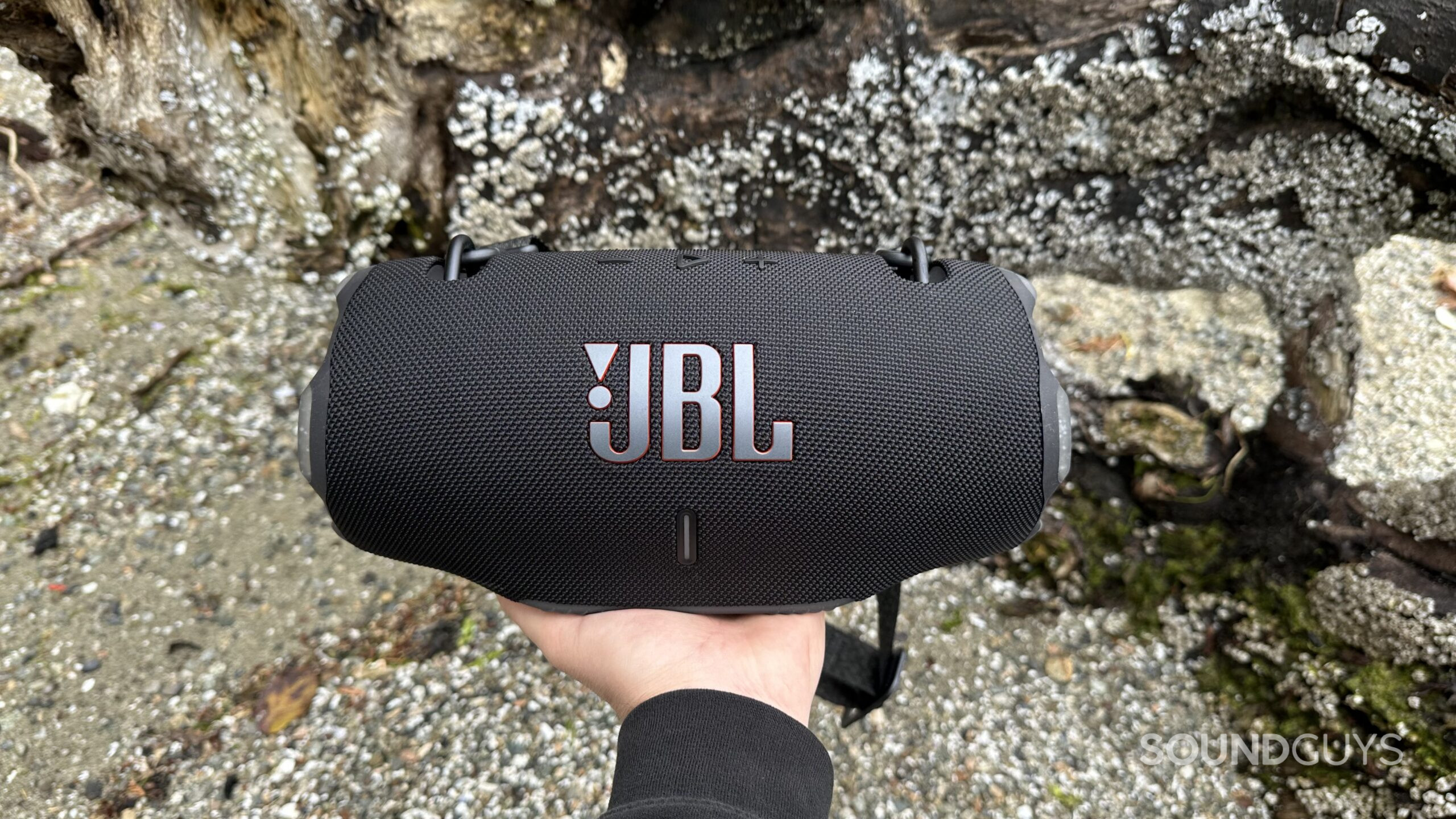 A hand holding the JBL Xtreme 4 speaker, directly facing the camera.