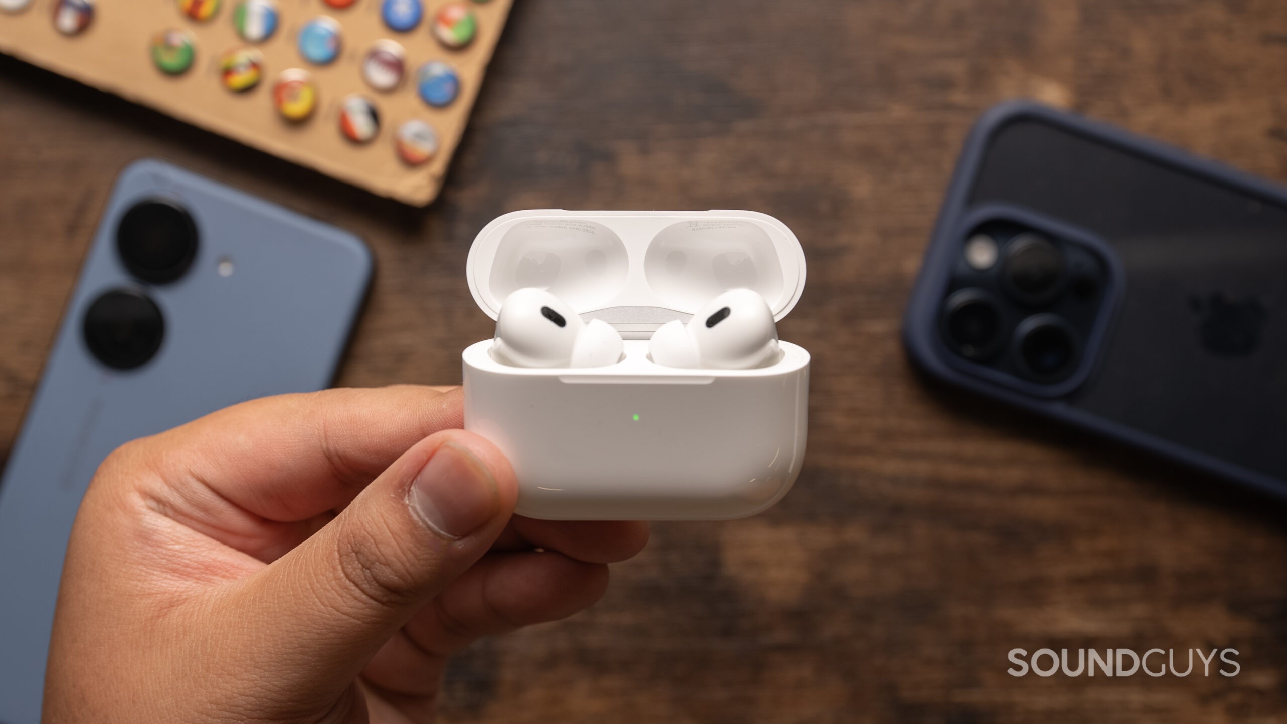 A hand holds the AirPods Pro (2nd generation).