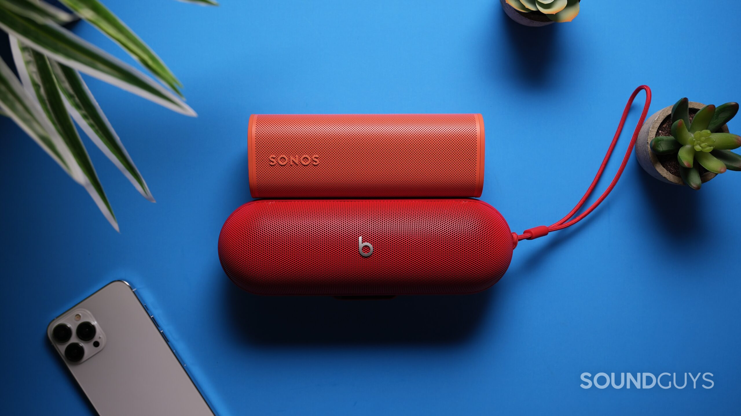 Top down shot of a a Sonos Roam above a Beats Pill with an iPhone 15 nearby 