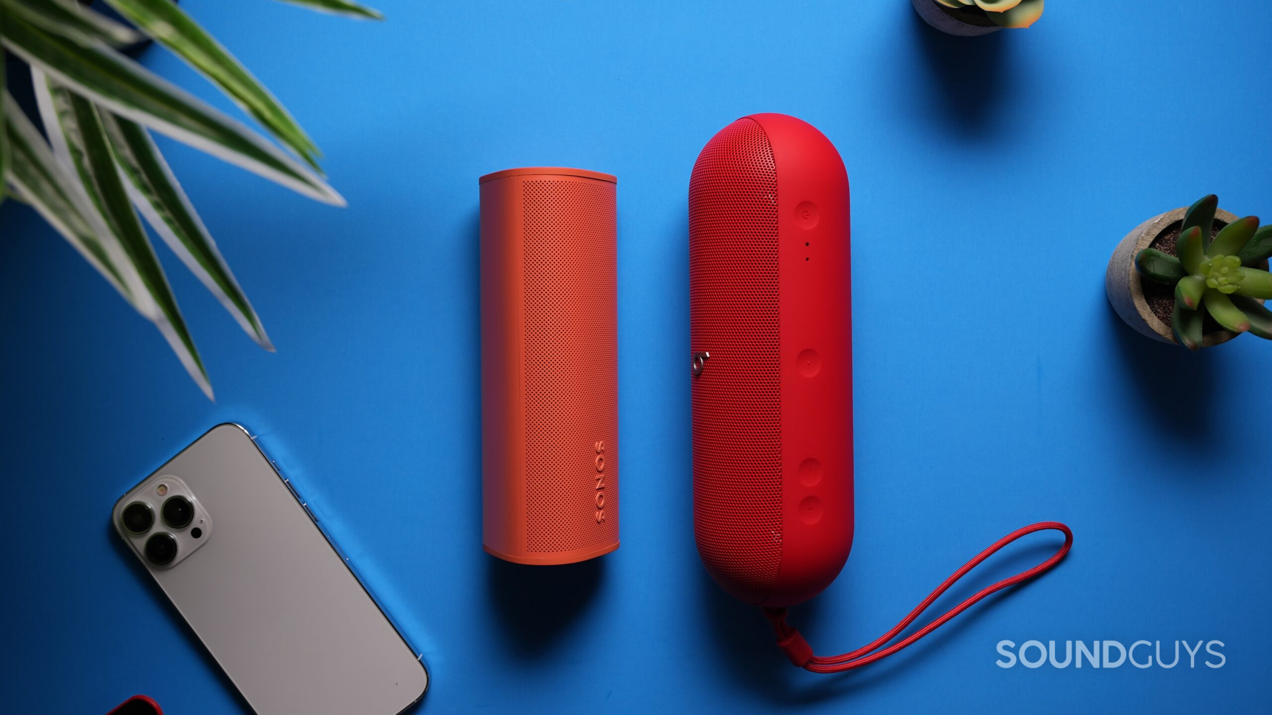 Top down shot of a Sonos Roam 2 lengthwise next to a Beats Pill