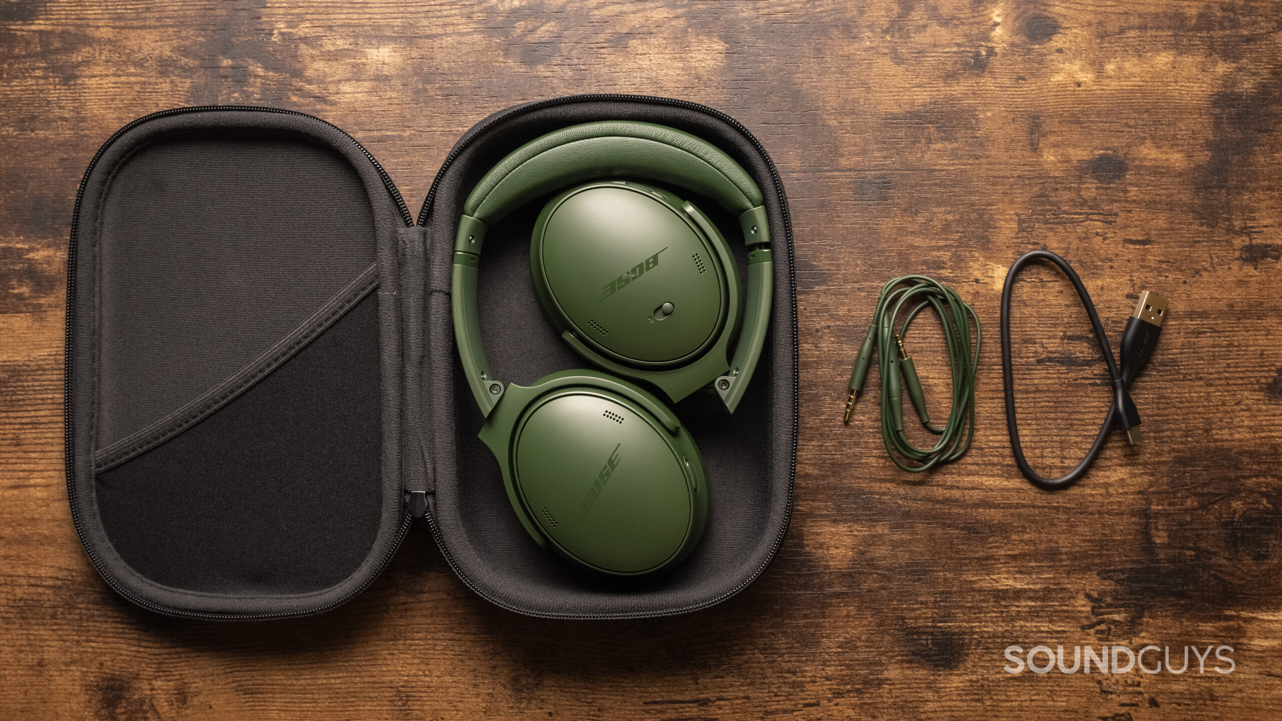 The Bose QuietComfort Headphones, sitting folded in their carrying case, along with the included cables.