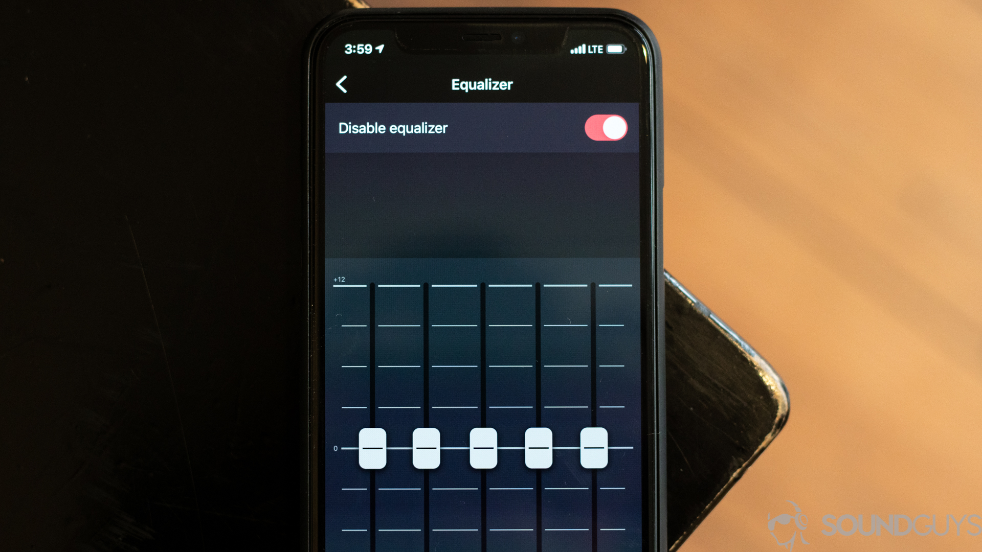 Pictured is an iPhone 11 Pro on a desk with the Deezer equalizer on the screen