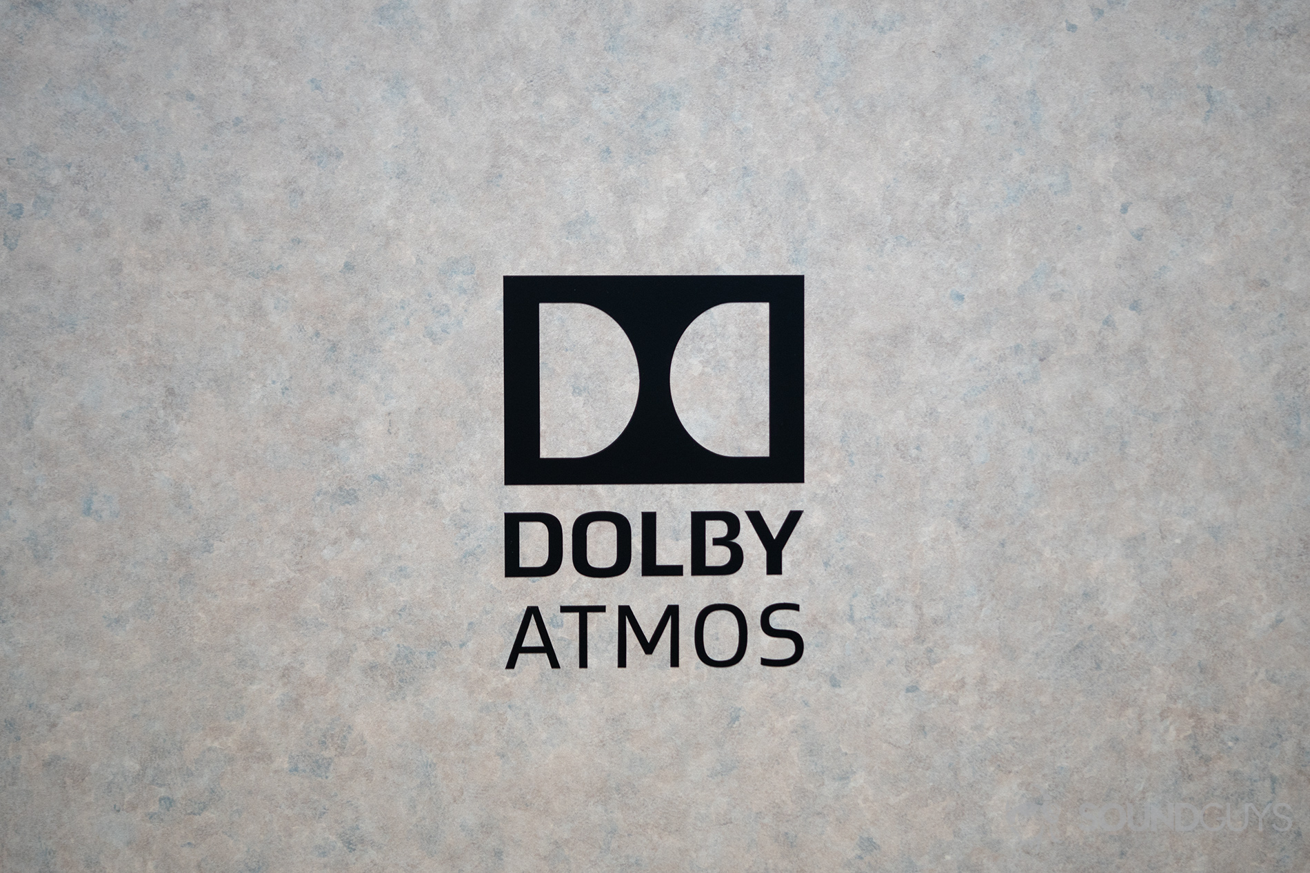 A black Dolby Atmos logo atop a marble backdrop.