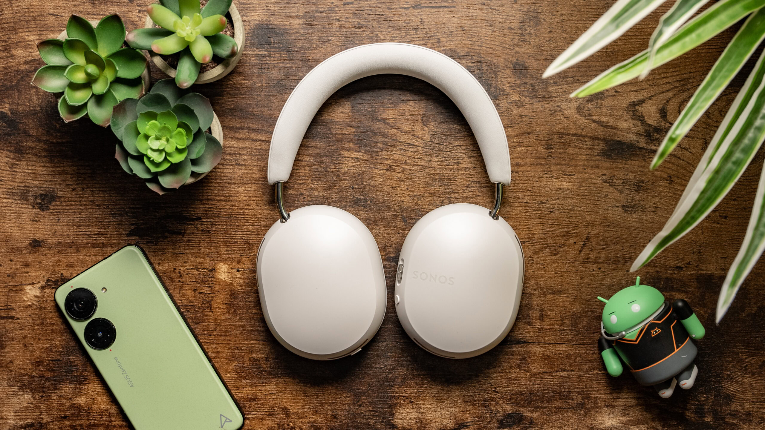 Top down photo of the Sonos Ace headphones folded flat onto a wooden table