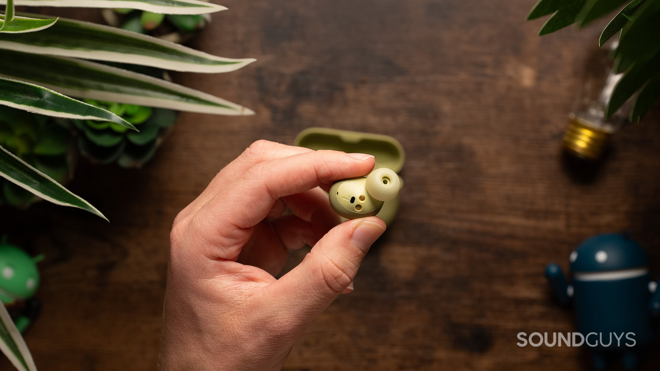 A hand holding a Jabra Elite 8 Active Gen 2 earbud. 