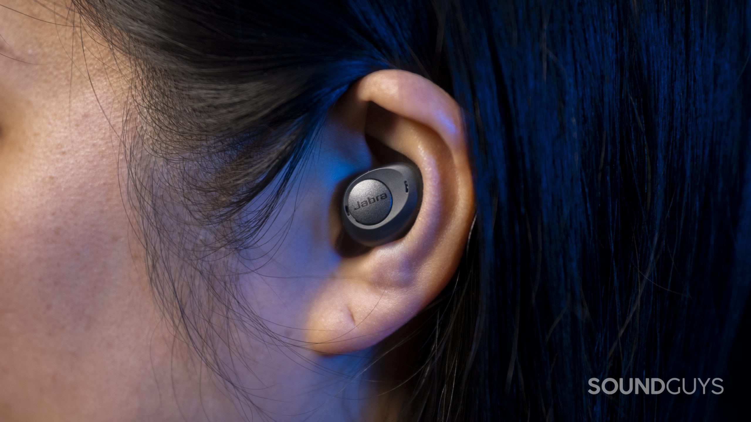 The Jabra Enhance Plus hearing aid hearable in a woman's left ear.