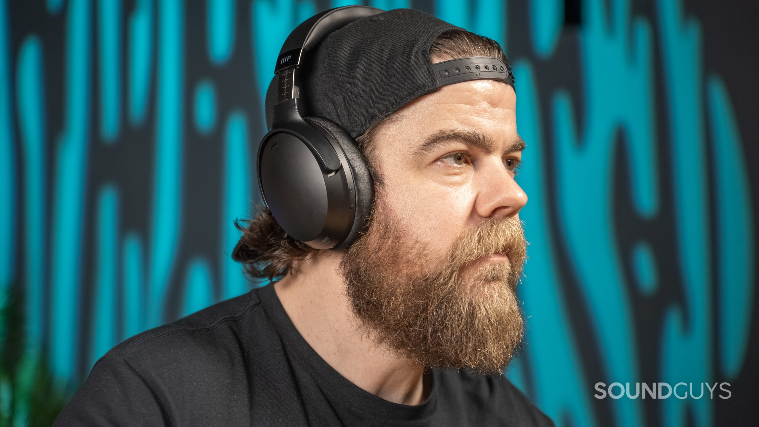 The Monoprice Dual Driver Bluetooth Headphones worn by bearded individual