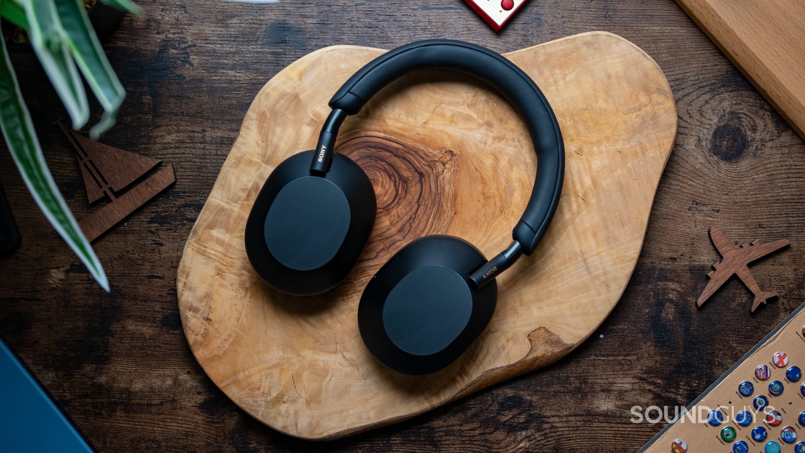 Sony WH-1000XM5 headphones laying flat on wooden table.