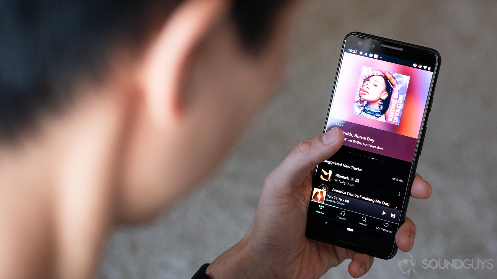 A woman holding a Google Pixel 3 with the Tidal HiFi app pulled up.