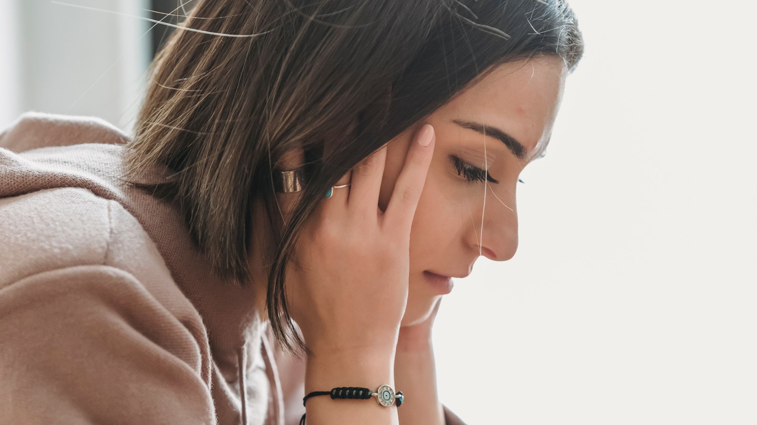 A young woman covering her ears.